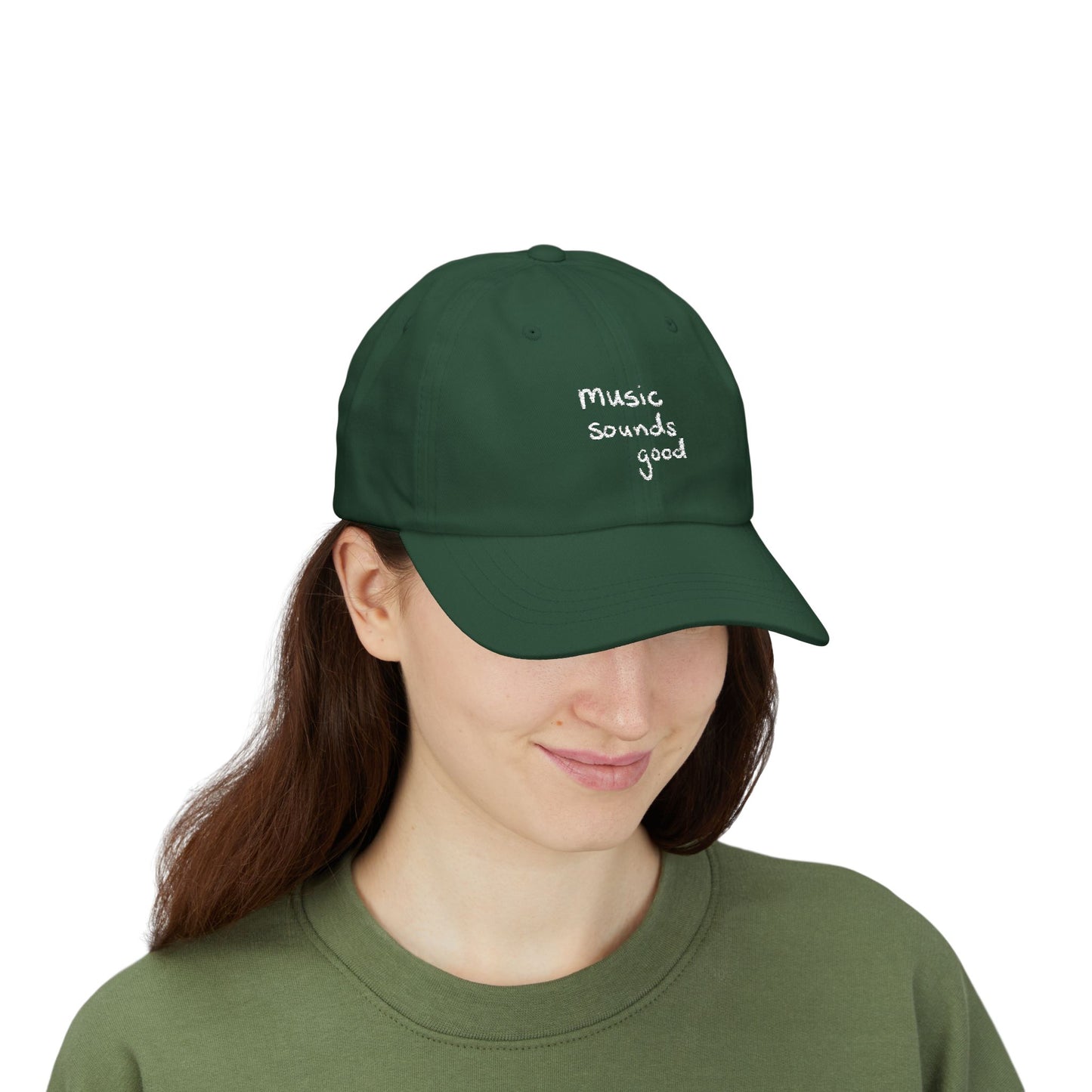 Woman wearing a green cap with 'music sounds good' text on a white background