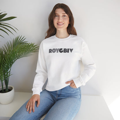 Woman wearing a white sweatshirt with 'ROYGBIV' text, sitting indoors with a plant in the background.