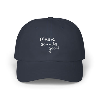 Navy blue cap with 'music sounds good' text on a white background