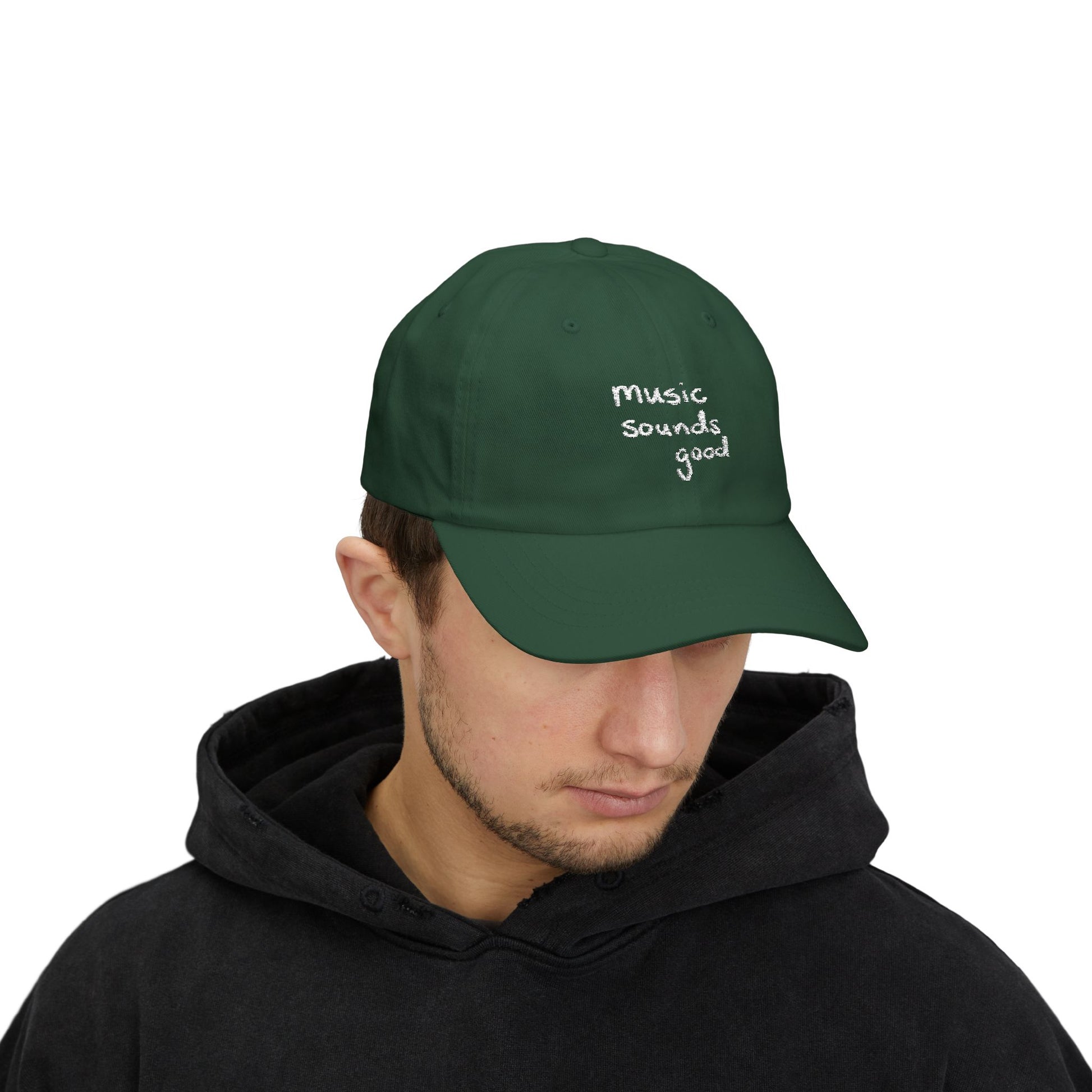 Person wearing a green cap with 'music sounds good' text on a white background