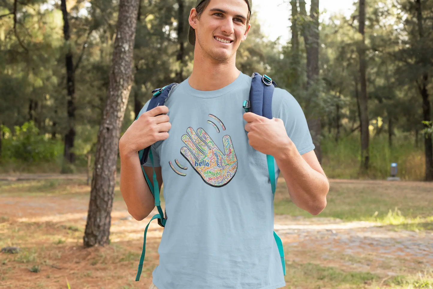 Man wearing a light blue Think a Thunk Hello ASL Hand Graphic Tee - Multi-Language Greeting T-Shirt outdoors.