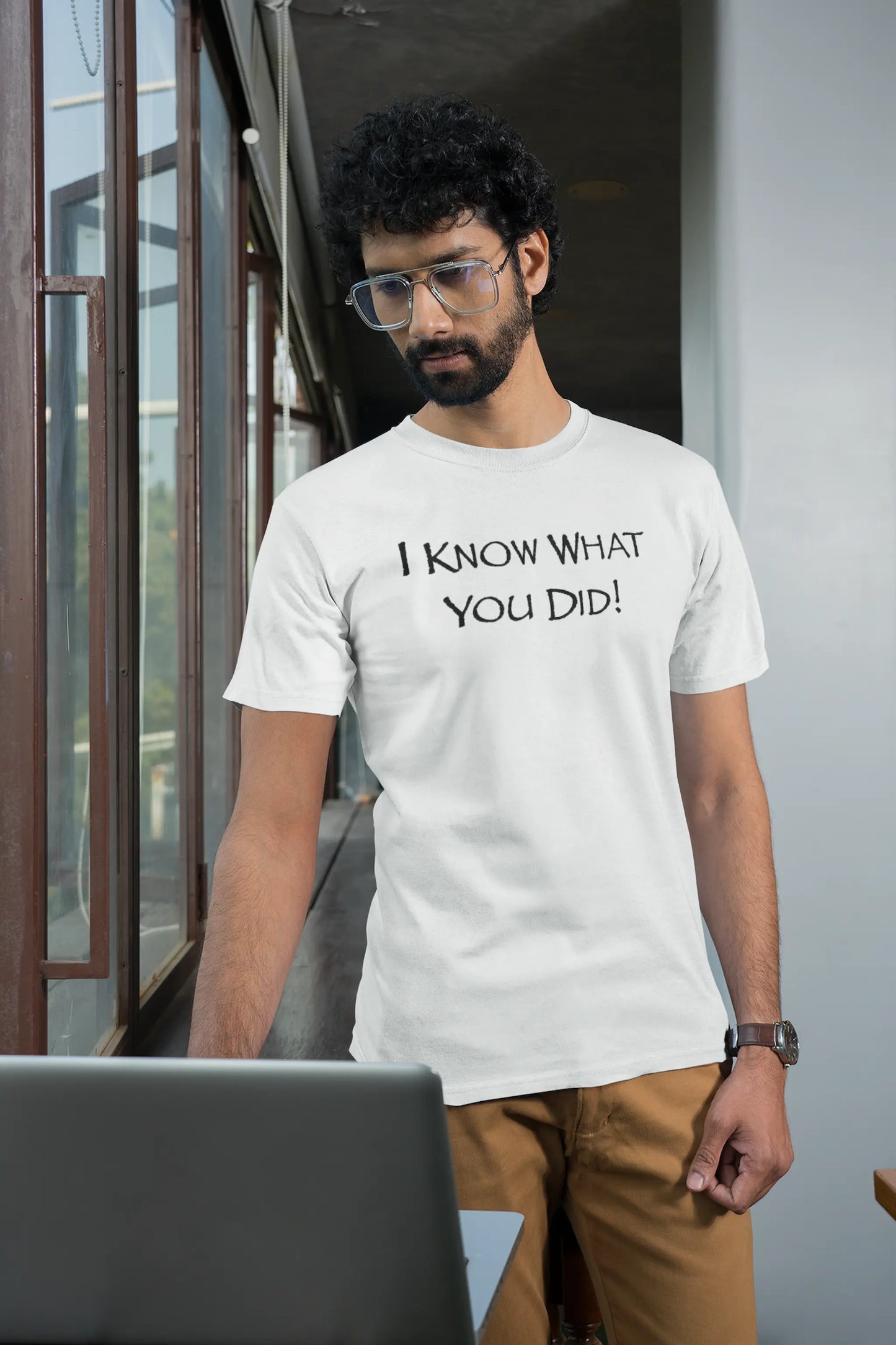 Man wearing a white Think a Thunk Unisex Papyrus Font SNL Inspired Graphic Tee standing indoors.