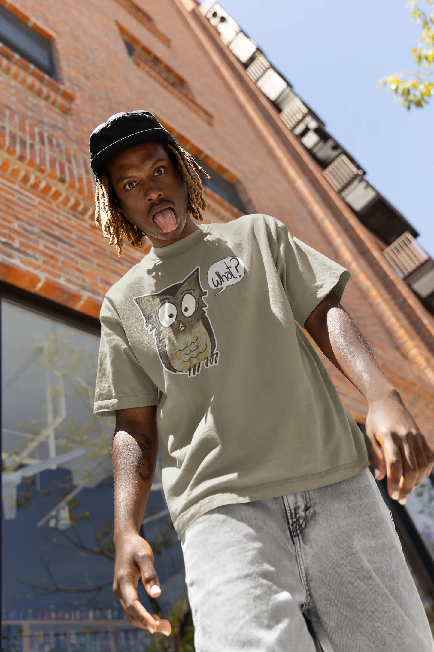 Low angle on man outside wearing a green Think a Thunk Unisex Perplexed Owl Organic T-Shirt