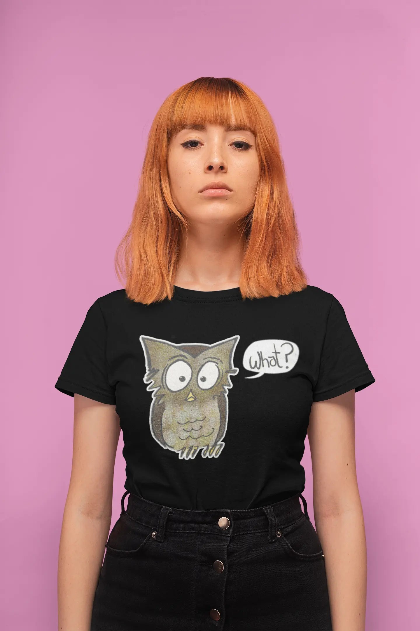 Person wearing a black t-shirt with an owl graphic and 'what?' text on a pink background