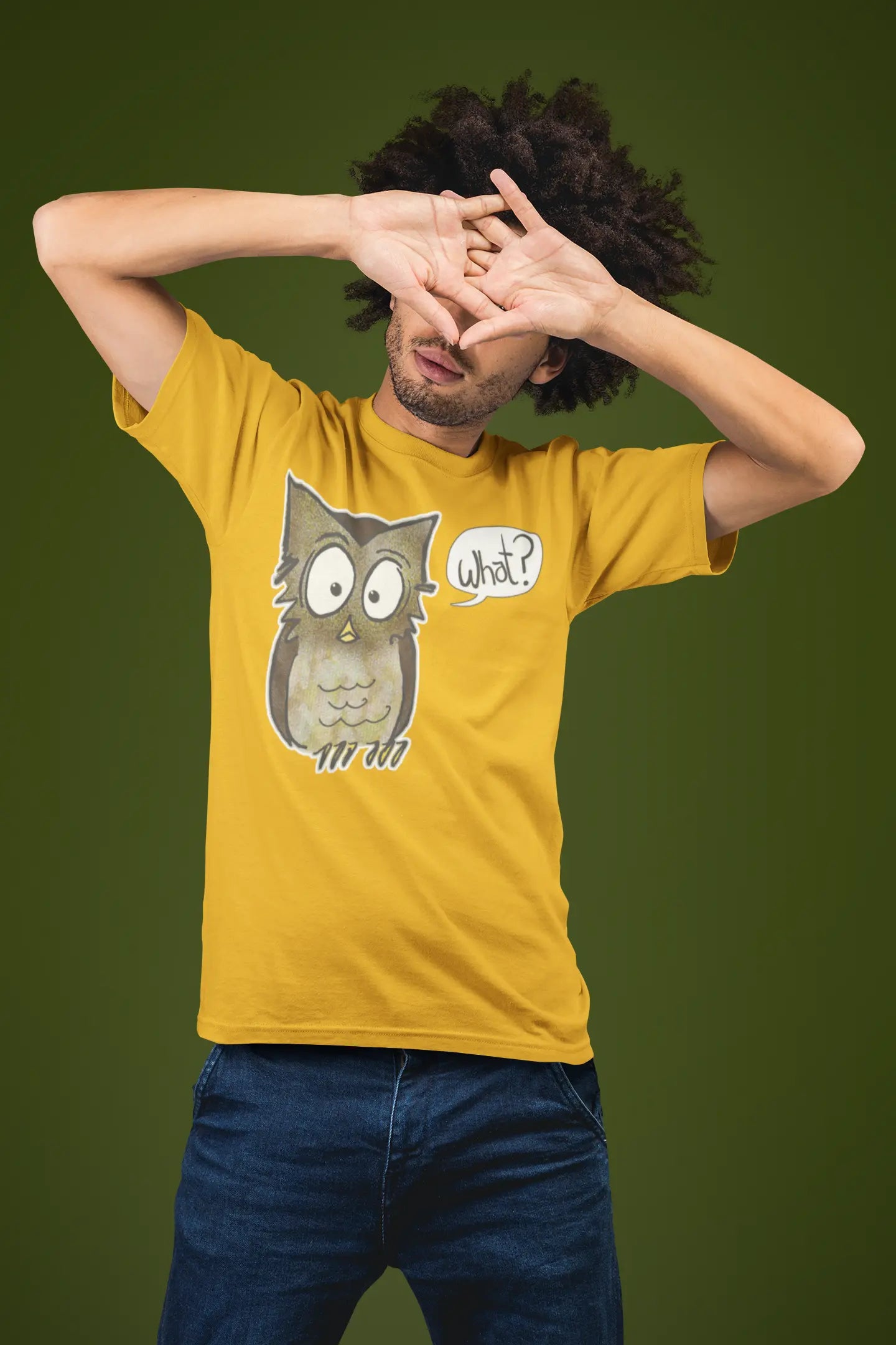 Person wearing a yellow t-shirt with an owl graphic and 'What?' text on a green background