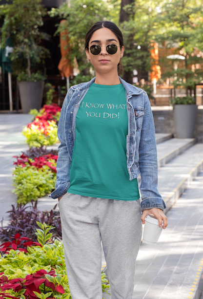Person wearing a jade t-shirt with text, denim jacket, and gray pants in an outdoor setting.
