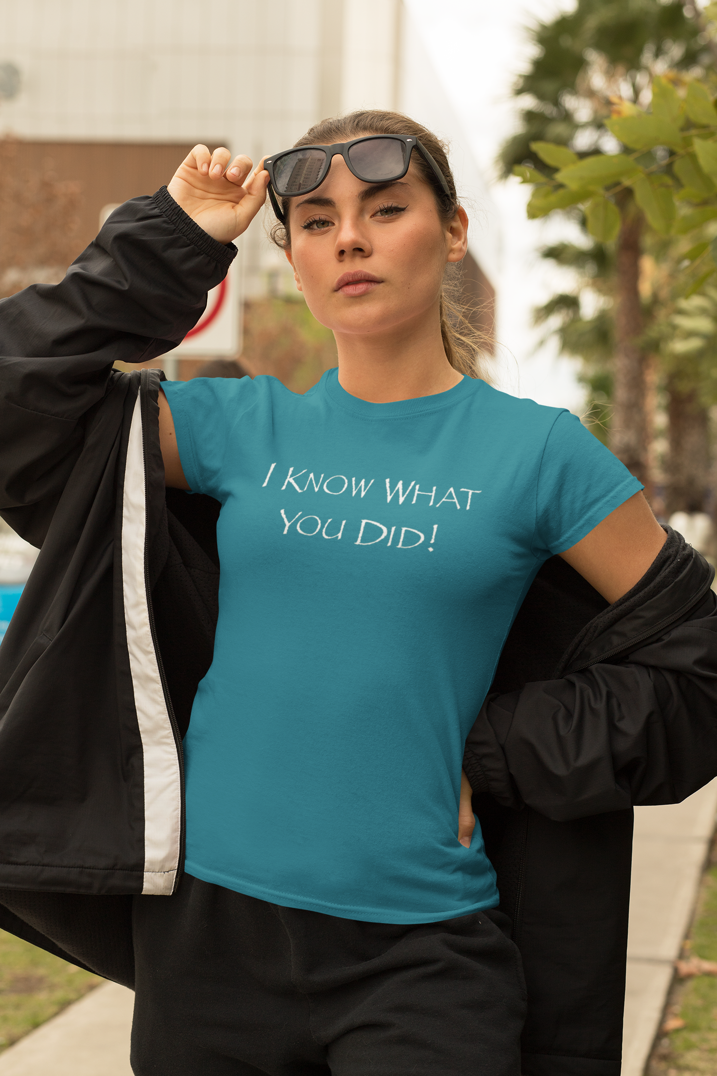 Woman wearing a antique sapphire t-shirt with "I Know What You Did!" text outdoors