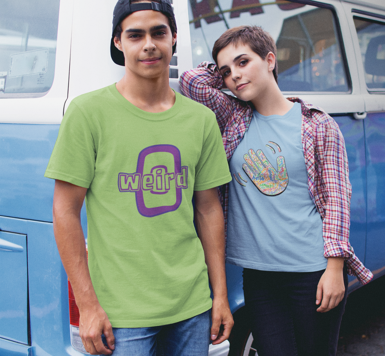 man wearing WEIRD-O T-shirt and woman wearing HELLO T-shirt standing beside a VW bus