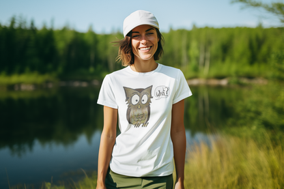 Woman wearing a white t-shirt with an owl design by a lake