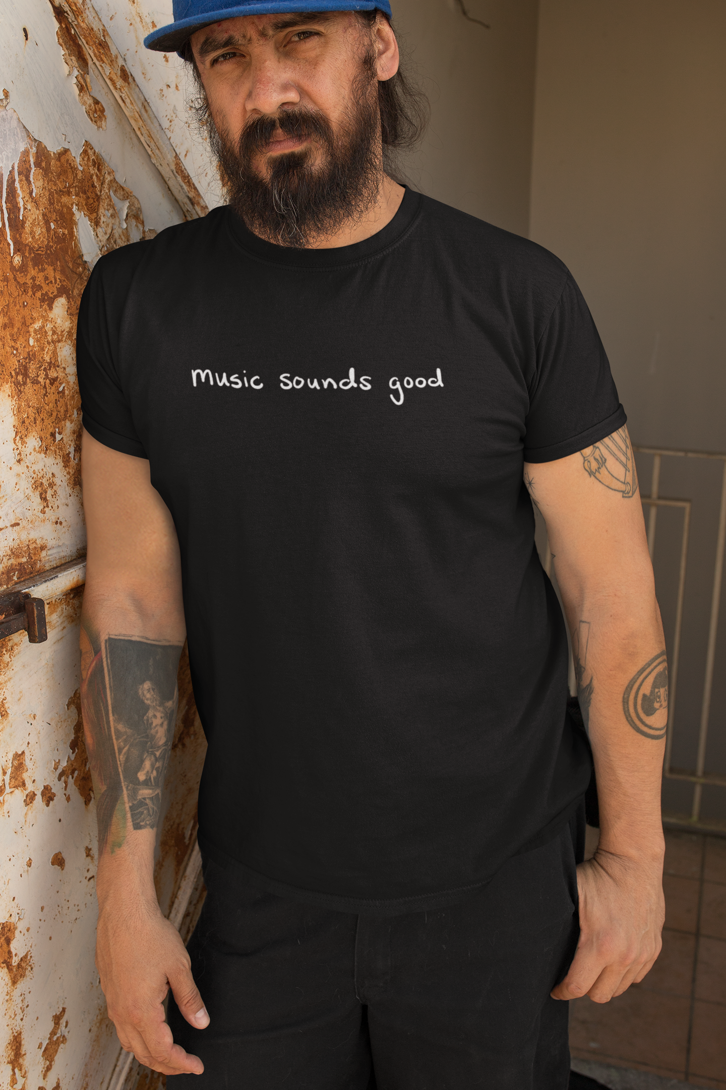 bearded man wearing MUSIC SOUNDS GOOD T-shirt