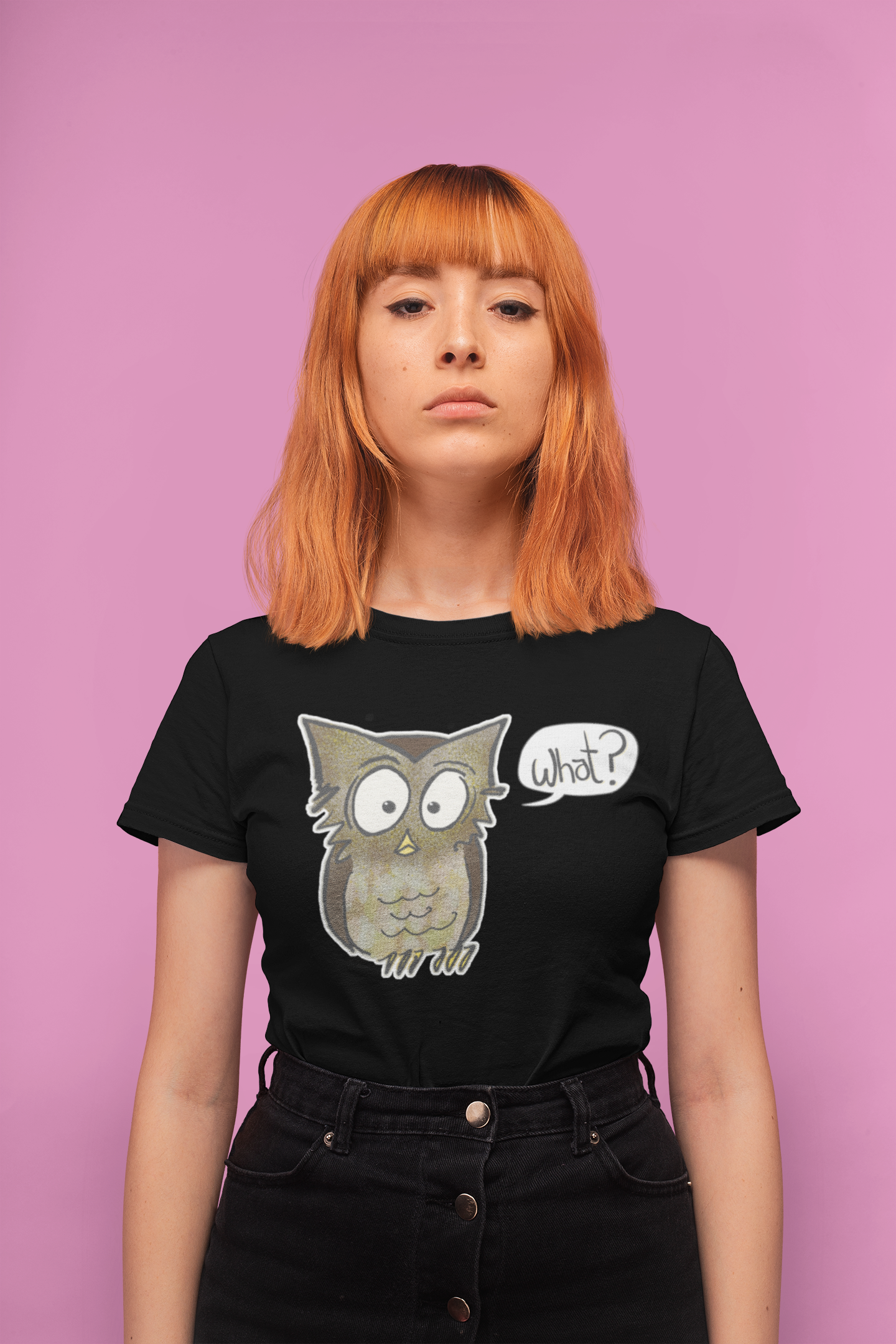 Woman wearing a black t-shirt with an owl graphic and 'What?' text on a pink background