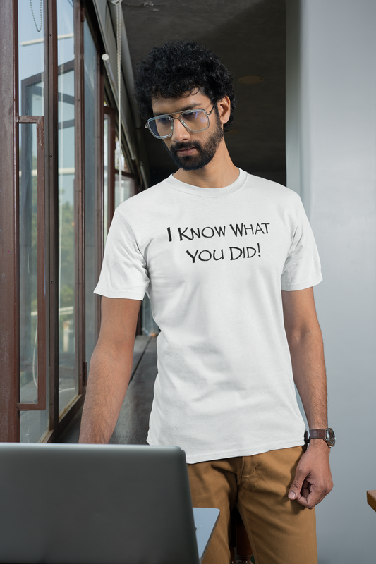 Man wearing a white t-shirt with text standing indoors.